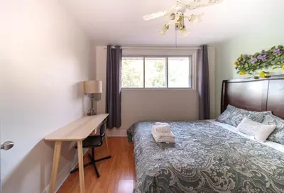 a bedroom with a bed with a desk and a window at 3 bedrooms in Brossard,mins to REM station,hwy in Brossard