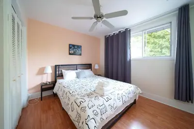 a bedroom with a bed and a ceiling fan at 3 bedrooms in Brossard,mins to REM station,hwy in Brossard