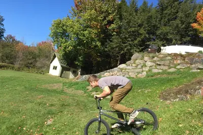 a man riding a bike in a field at House and treehouse near 2 ski resorts in Lac-Brome