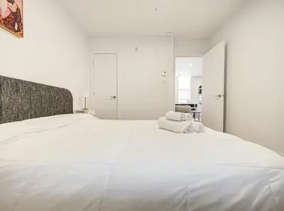 a white bedroom with a large white bed at Stunning 2 Bedroom Downtown Montreal in Montréal