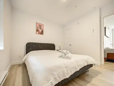 a bedroom with a bed with two towels on it at Stunning 2 Bedroom Downtown Montreal in Montréal