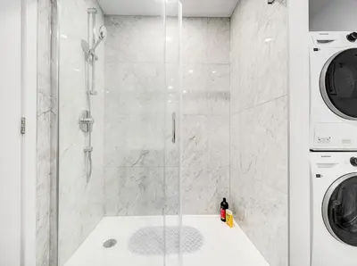 a shower in a bathroom with a washer and dryer at Stunning 2 Bedroom Downtown Montreal in Montréal
