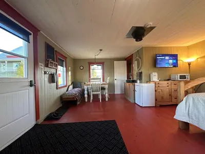 a room with a kitchen and a room with a table at La laiterie in Ham Nord