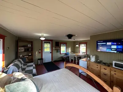 a living room with a couch and a tv at La laiterie in Ham Nord