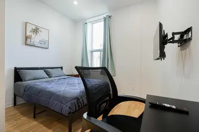 a bedroom with a bed and a tv in it at Cozy Studio Near Downtown Montreal with Parking in Montréal