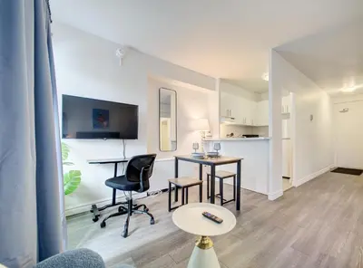 a living room with a table and chairs and a kitchen at Elegant Studio in DT MTL AC, Wi-Fi in Montréal