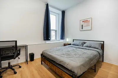 a bedroom with a bed and a desk and a window at Well located studio apartment with parking near downtown Montreal in Montréal