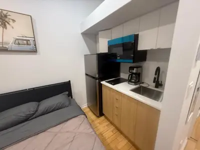 a small room with a bed and a kitchen at Well located studio apartment with parking near downtown Montreal in Montréal