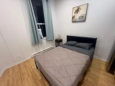 a bedroom with a bed in a room with a window at Well located studio apartment with parking near downtown Montreal in Montréal