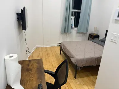 a room with a bed and a table with a desk at Well located studio apartment with parking near downtown Montreal in Montréal