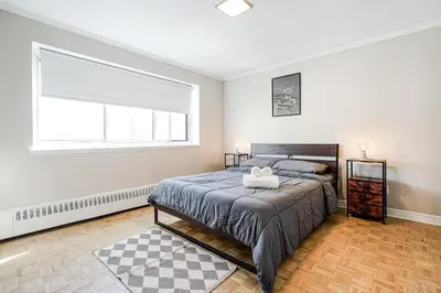 a bedroom with a bed and a large window at Downtown Montreal 2-Bedroom Gem near Bell Centre in Montréal