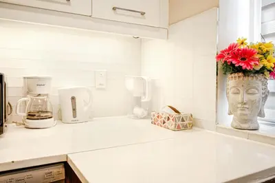 a kitchen counter with a vase with a face on it at Downtown Montreal 2-Bedroom Gem near Bell Centre in Montréal