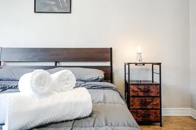a bedroom with two beds and a night stand at Downtown Montreal 2-Bedroom Gem near Bell Centre in Montréal