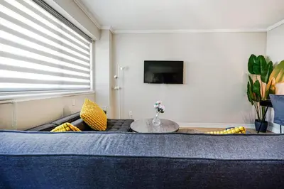 a living room with a bed and a table at Downtown Montreal 2-Bedroom Gem near Bell Centre in Montréal