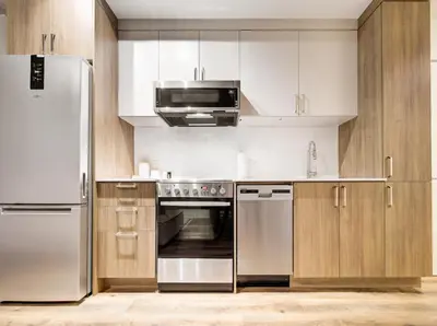 a kitchen with stainless steel appliances and wooden cabinets at Amazing 1Bed Downtown Mtl in Montréal