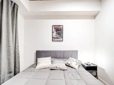 a bedroom with a gray bed with pillows on it at Amazing 1Bed Downtown Mtl in Montréal