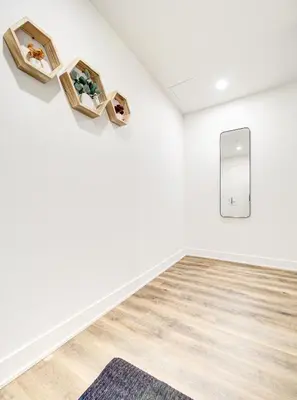 a room with white walls and wooden floors and a mirror at Amazing 1Bed Downtown Mtl in Montréal