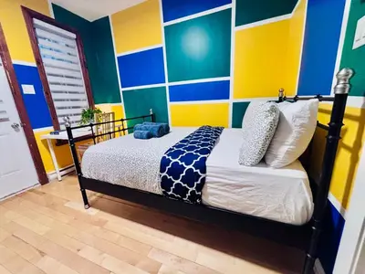 a bedroom with a bed with blue and yellow stripes at Sunrise Haven in Montréal