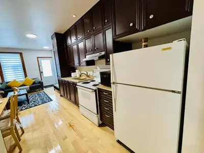 a kitchen with a white refrigerator and wooden cabinets at Sunrise Haven in Montréal