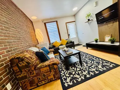 a living room with a couch and a brick wall at Sunrise Haven in Montréal