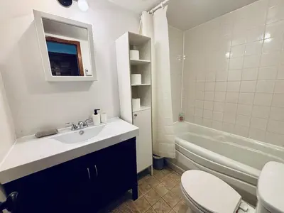 a bathroom with a sink and a toilet and a tub at Sunrise Haven in Montréal