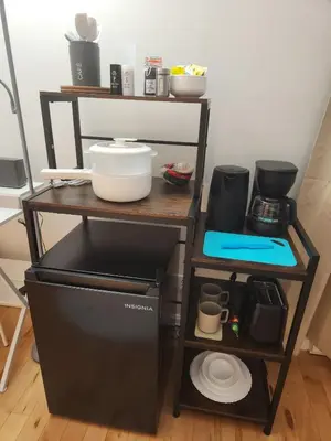 a kitchen with a refrigerator and a shelf with dishes at Chambre Zen, Résidence paisible près de Montréal in Longueuil