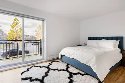 a bedroom with a bed and a large window at Verone 4 Appartement 4,5 Meublé 2ch Laval, Canada in Laval