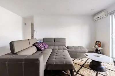 a living room with a large couch and a table at Verone 4 Appartement 4,5 Meublé 2ch Laval, Canada in Laval