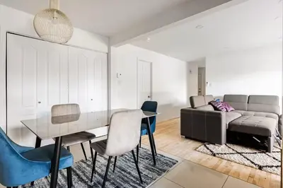a dining room with a table and a couch at Verone 4 Appartement 4,5 Meublé 2ch Laval, Canada in Laval