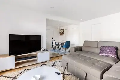 a living room with a couch and a flat screen tv at Verone 4 Appartement 4,5 Meublé 2ch Laval, Canada in Laval