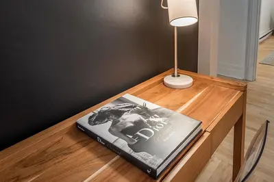 a book sitting on a wooden table with a lamp at 4BR Penthouse - Parking - 2 King & 2 Queen in Montréal