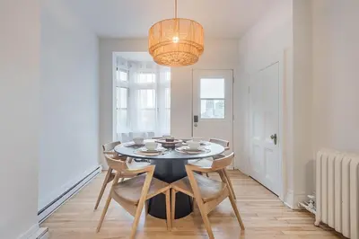 a dining room with a table with chairs and a chandelier at 4BR Penthouse - Parking - 2 King & 2 Queen in Montréal