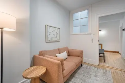 a living room with a couch and a table at 4BR Penthouse - Parking - 2 King & 2 Queen in Montréal
