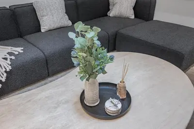 a living room with a table with a vase with flowers at Downtown Core - Ultra Modern 1 Bedroom Apartment in Montréal