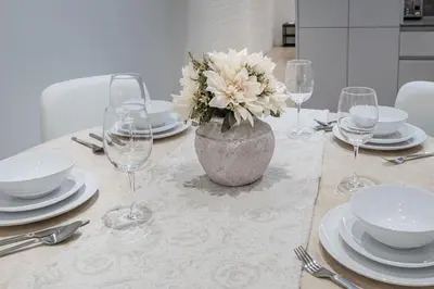 a table with plates and glasses and a vase with flowers at Downtown Core - Ultra Modern 1 Bedroom Apartment in Montréal