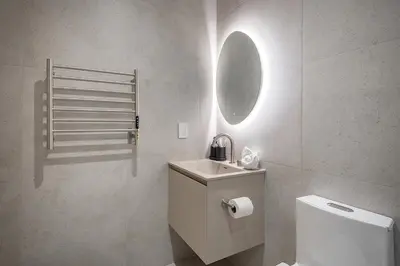 a bathroom with a toilet and a sink and a mirror at Downtown Core - Ultra Modern 1 Bedroom Apartment in Montréal