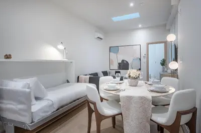 a white living room with a table and chairs at Downtown Core - Ultra Modern 1 Bedroom Apartment in Montréal