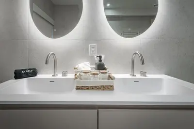 a bathroom with two sinks and two mirrors at Luxury 4BR 3BA Penthouse with Private Terrace in Montréal