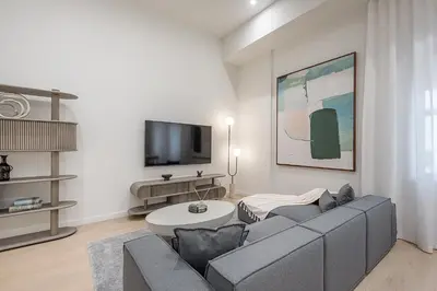 a living room with a gray couch and a tv at Luxury 4BR 3BA Penthouse with Private Terrace in Montréal