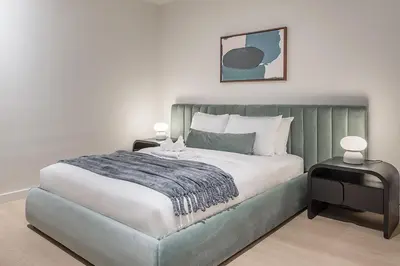 a bedroom with a bed with a green headboard at Luxury 4BR 3BA Penthouse with Private Terrace in Montréal