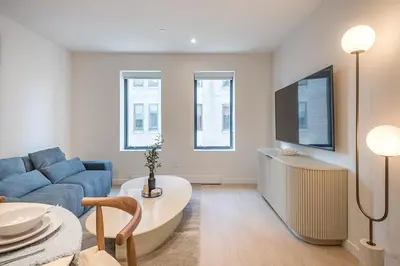 a living room with a blue couch and a tv at Bright & Modern 2BR - Golden Square Mile in Montréal