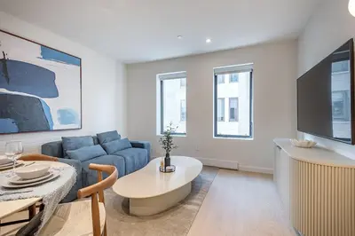 a living room with a blue couch and a table at Bright & Modern 2BR - Golden Square Mile in Montréal