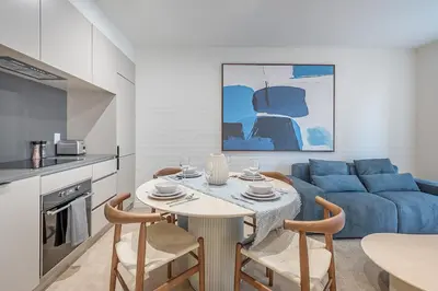 a living room with a table and a blue couch at Bright & Modern 2BR - Golden Square Mile in Montréal