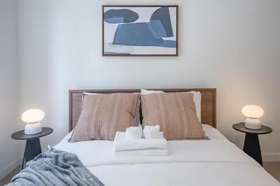a bedroom with a bed with two lamps on both sides at Bright & Modern 2BR - Golden Square Mile in Montréal