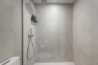 a bathroom with a shower with a glass door at Bright & Modern 2BR - Golden Square Mile in Montréal
