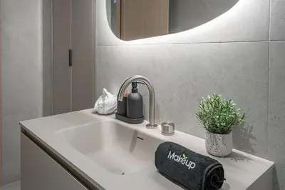 a bathroom sink with a bottle of alcohol on it at Bright & Modern 2BR - Golden Square Mile in Montréal