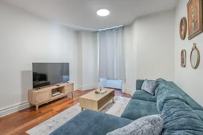 a living room with a blue couch and a tv at Elegant 3BR - High Ceilings & Vintage Charm in Montréal