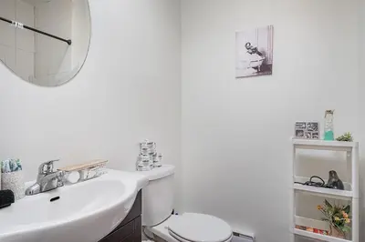 a bathroom with a sink and a toilet and a mirror at Elegant 3BR - High Ceilings & Vintage Charm in Montréal