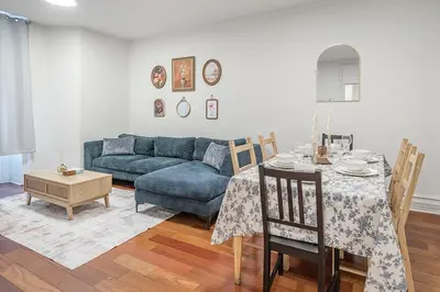 a living room with a blue couch and a table at Elegant 3BR - High Ceilings & Vintage Charm in Montréal