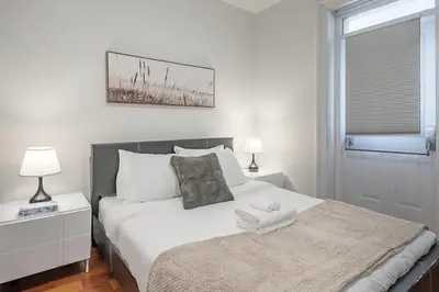 a bedroom with a white bed and a window at Elegant 3BR - High Ceilings & Vintage Charm in Montréal